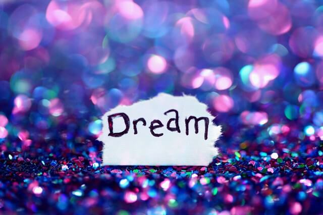 キラキラ輝くスパンコールの上にDreamと書かれた紙が落ちている。